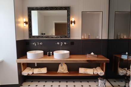 Salle de bain de la Chambre Deluxe du Château de Germigney avec double vasque et décoration élégante.