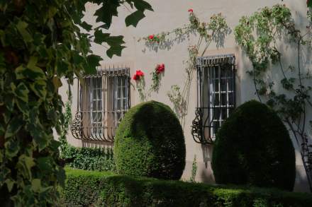 Façade du Château de Germigney ornée de rosiers grimpants et de jardins soignés.