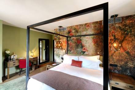 Chambre Zen Prestige du Château de Germigney avec lit à baldaquin et décoration murale élégante.